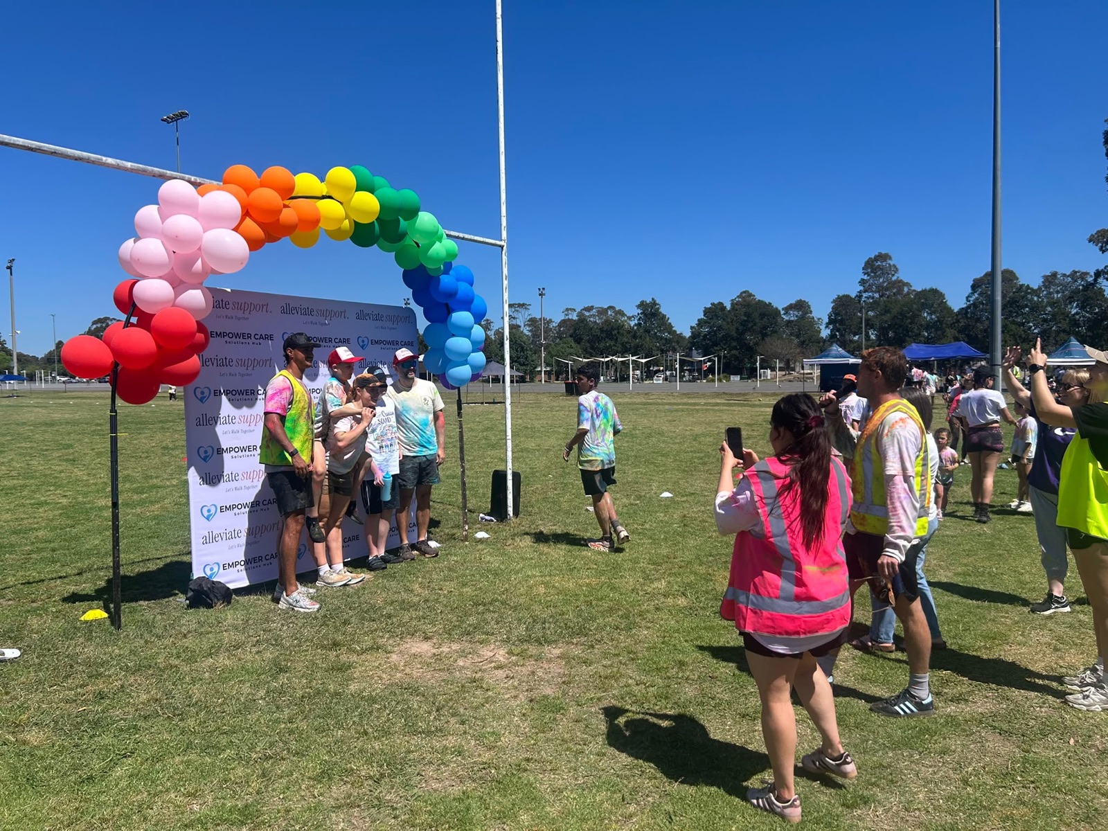 Runners gathering near the rainbow balloon arch on the oval