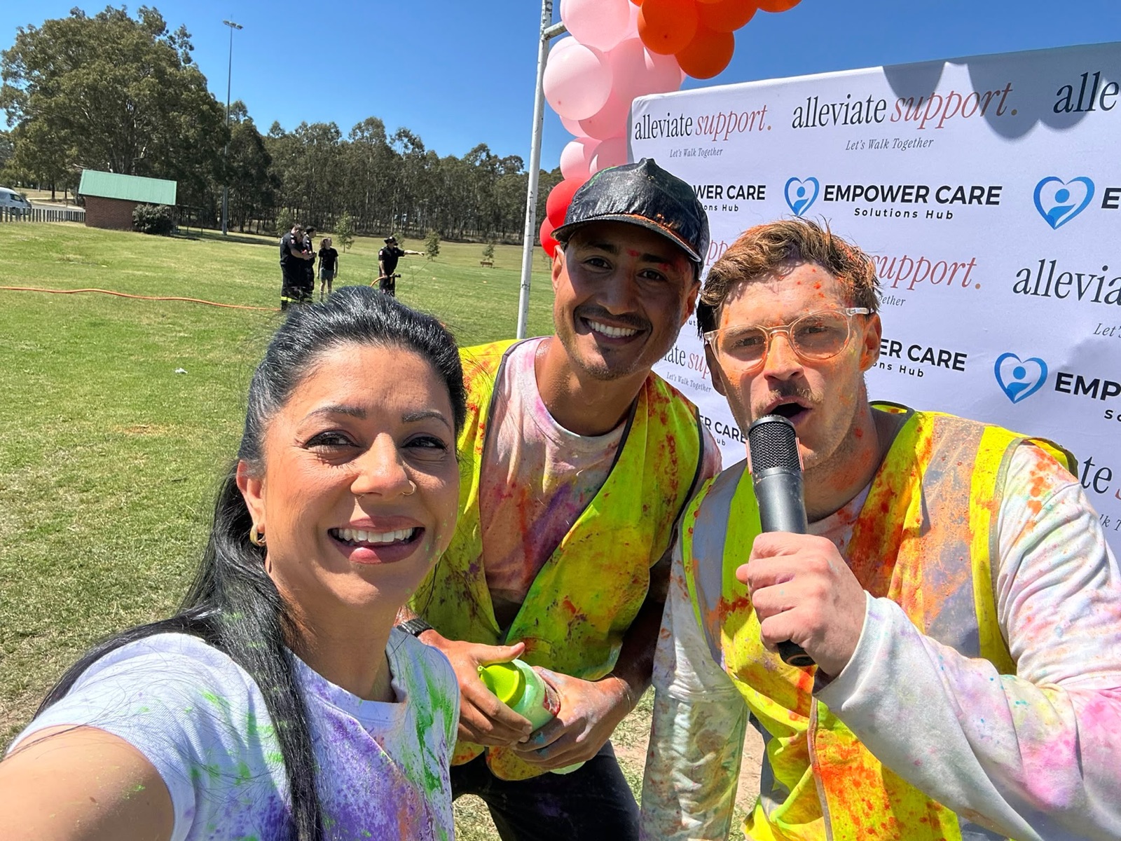 The MC and team members smiling, covered in colour